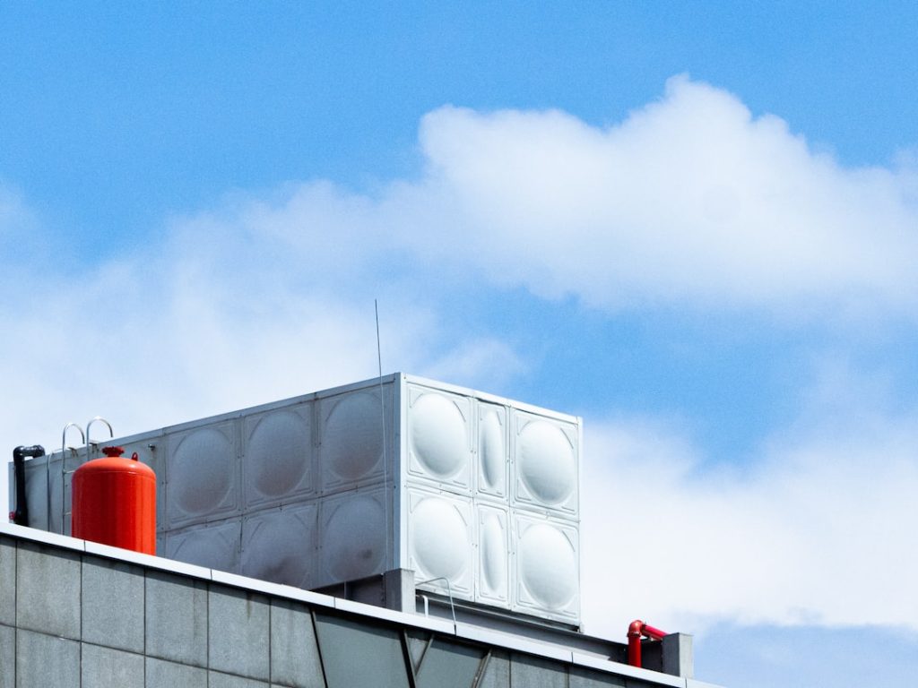 a-tall-building-with-a-red-and-white-object-on-top-of-it-yvkllkmnw-e