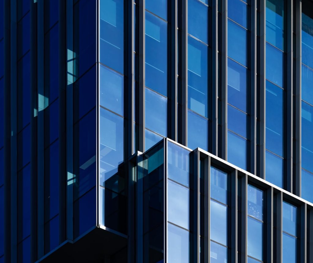 a-tall-building-with-lots-of-windows-next-to-a-street-sign-ltpdziwkyr8