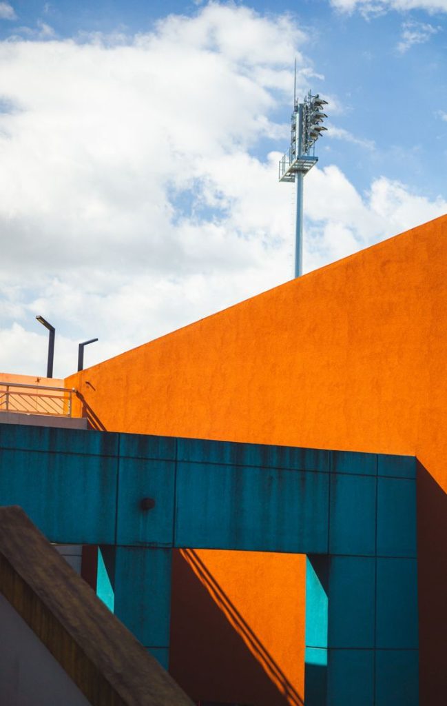 Vibrant capture of modern architecture with bold color contrasts and geometric shapes against a blue sky.